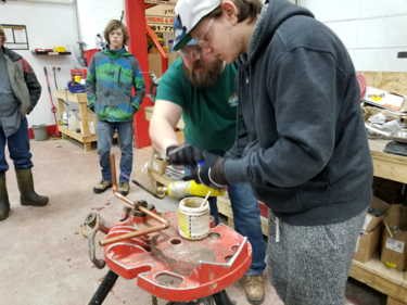 Bridge Network Outreach School Grade 12 student James Godfrey following the instructions of Kelly Wilson, Manager at M&R Pluming on how to weld copper pipes. During a Tour of the Trades event — in Grande Prairie, Alberta.