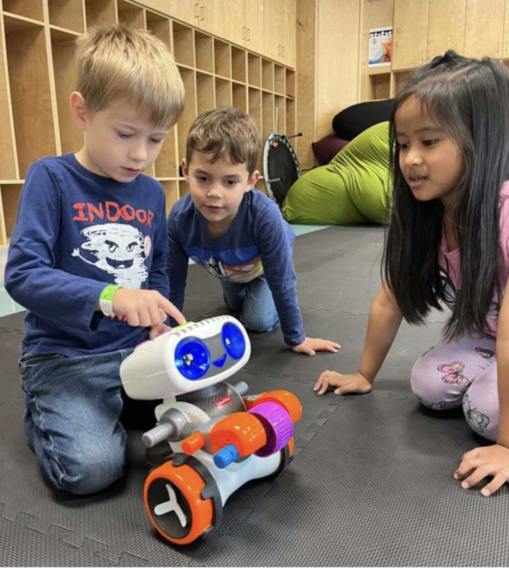 young students playing with a robot