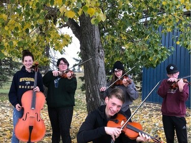 group of musicians with their instruments outside by a tree